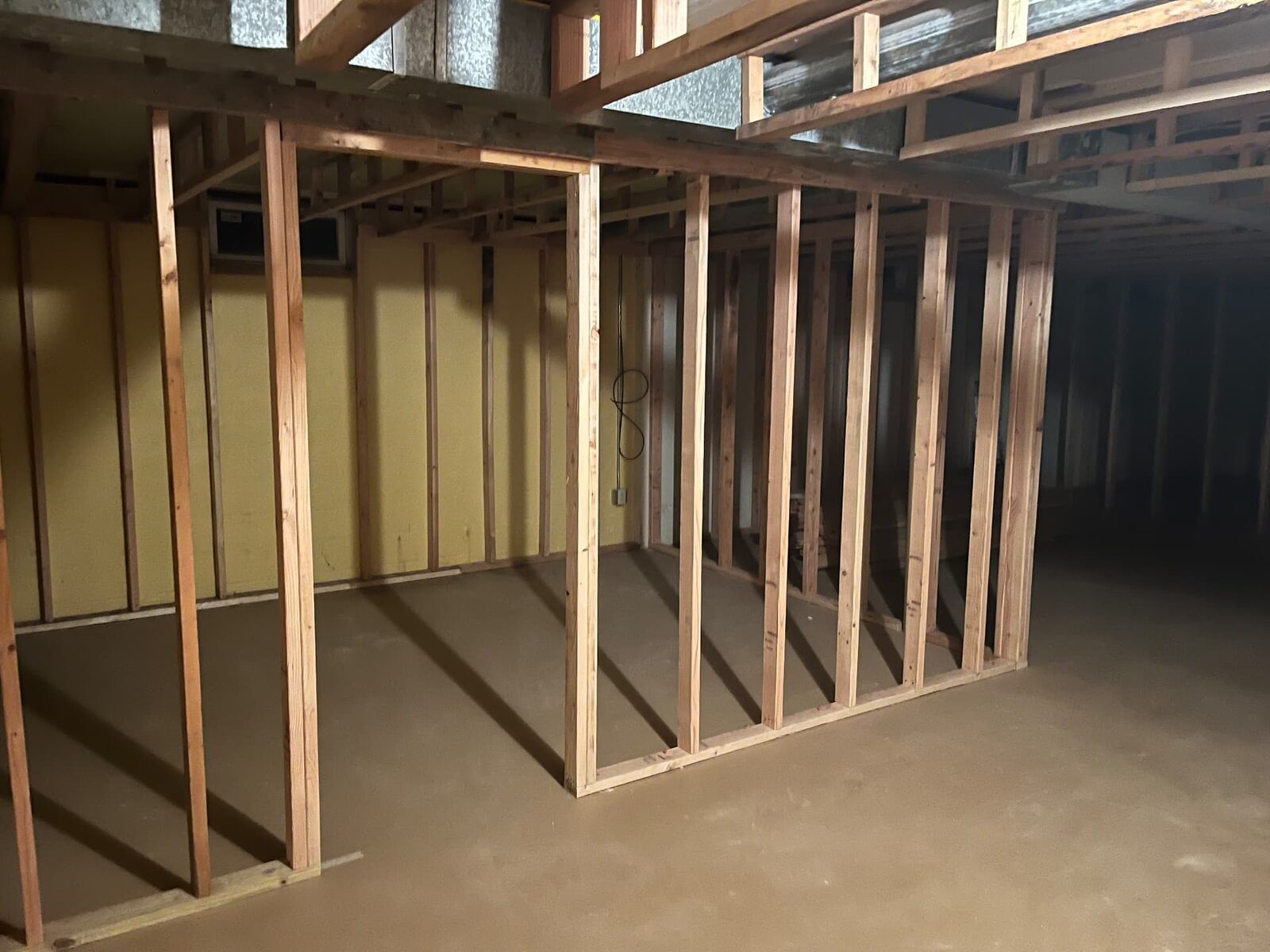 Close view of basement stud framing and ceiling joists during construction