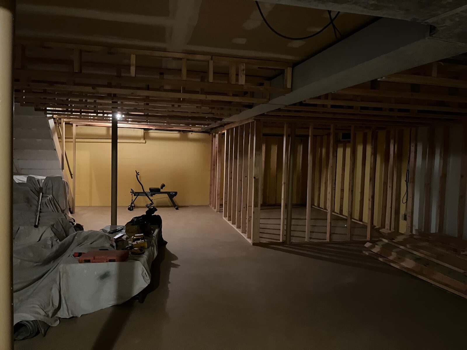Wide view of a basement with new wood stud framing laid out for multiple rooms