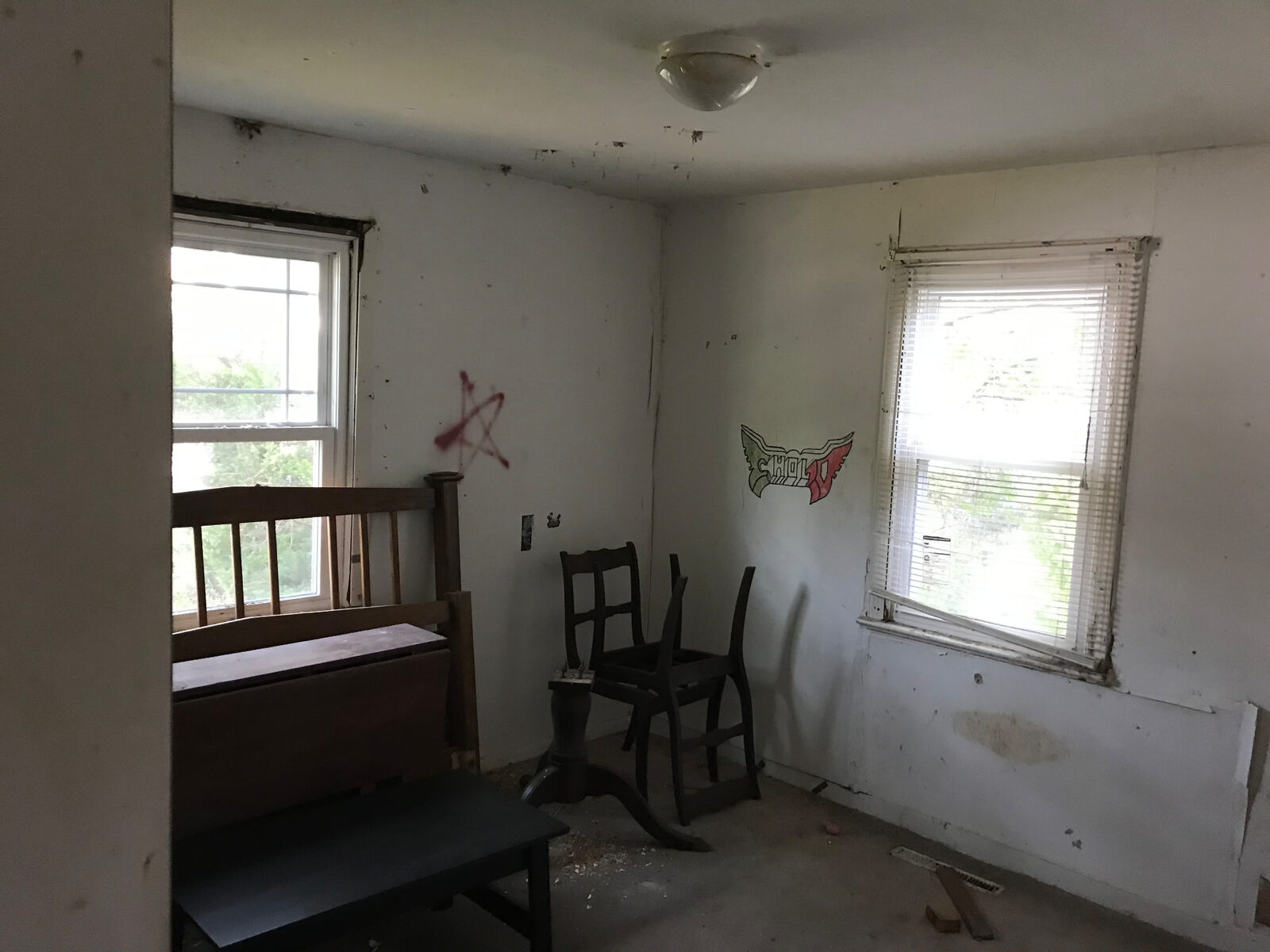 Vacant property interior with left-behind furniture, damaged walls and graffiti