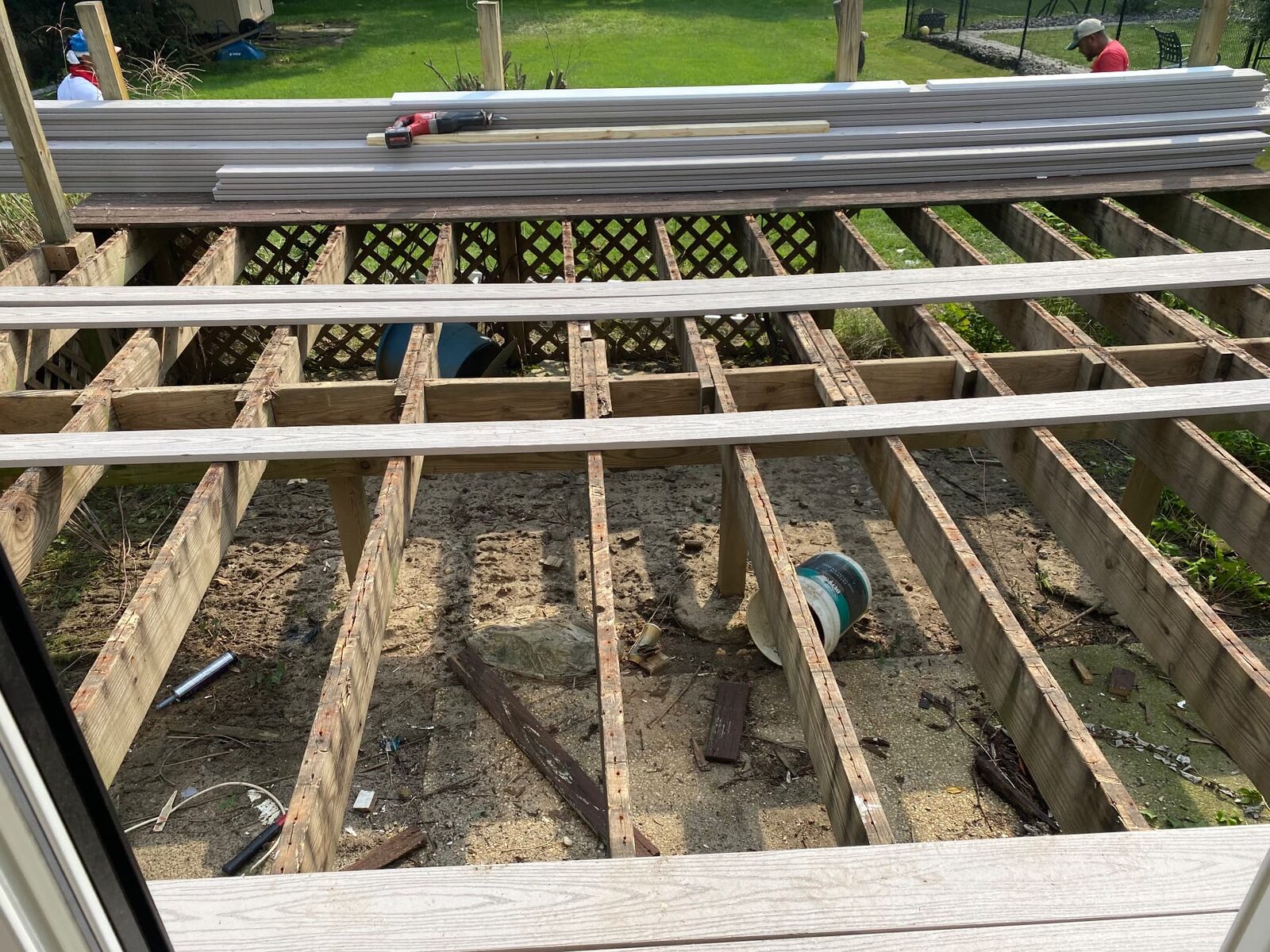 Deck rebuild in progress with old boards removed, framing exposed and new decking staged on top