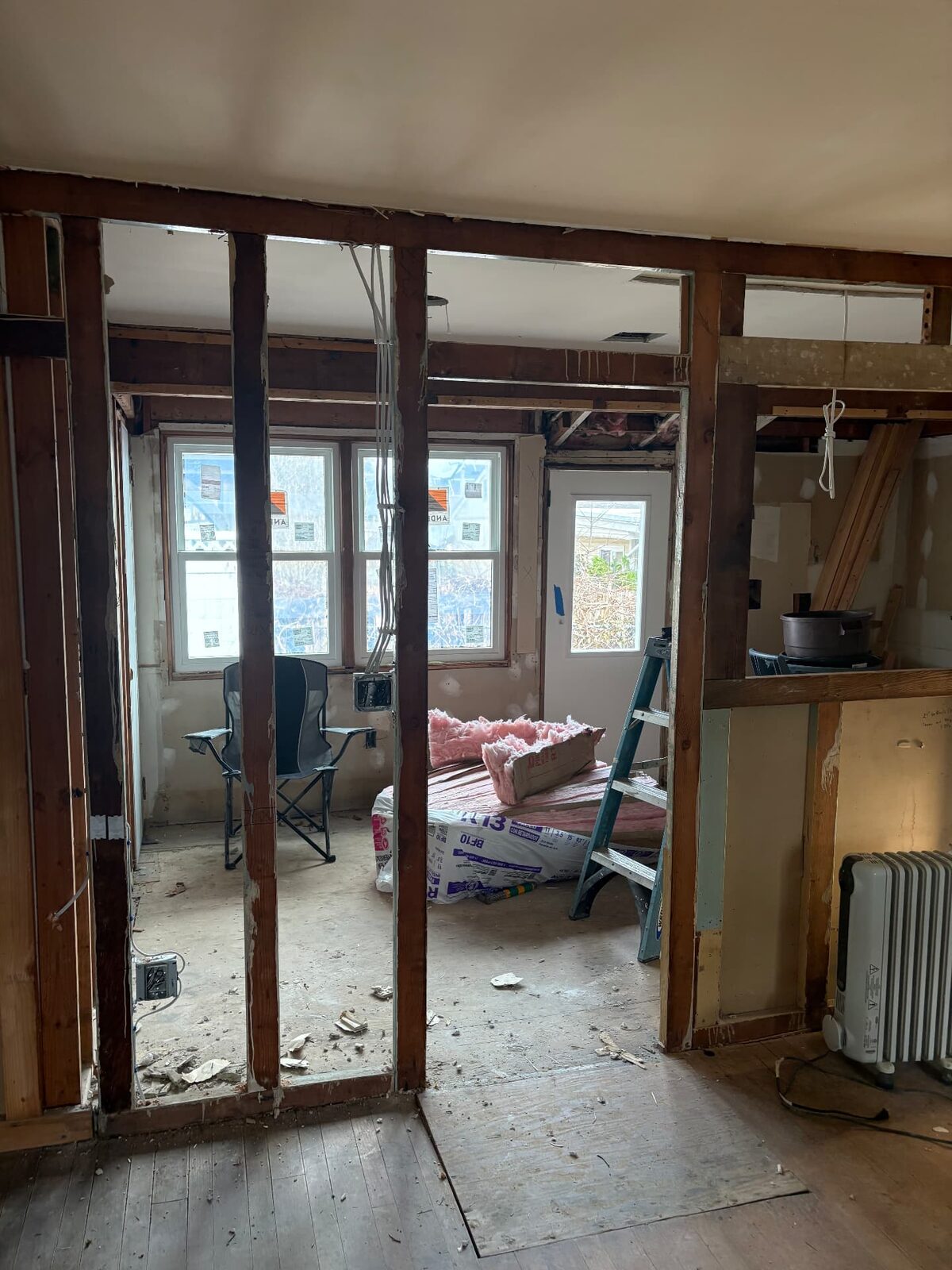 Interior walls stripped back to bare studs during demolition, with openings framed out