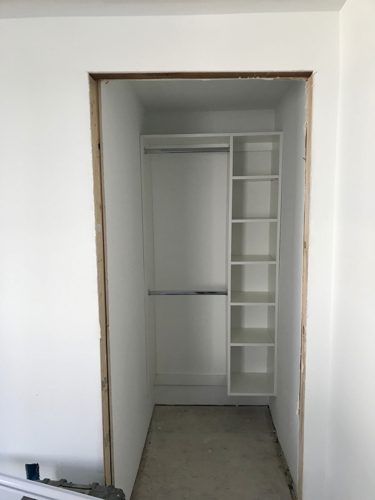 Finished closet interior with new white shelving and hanging rods