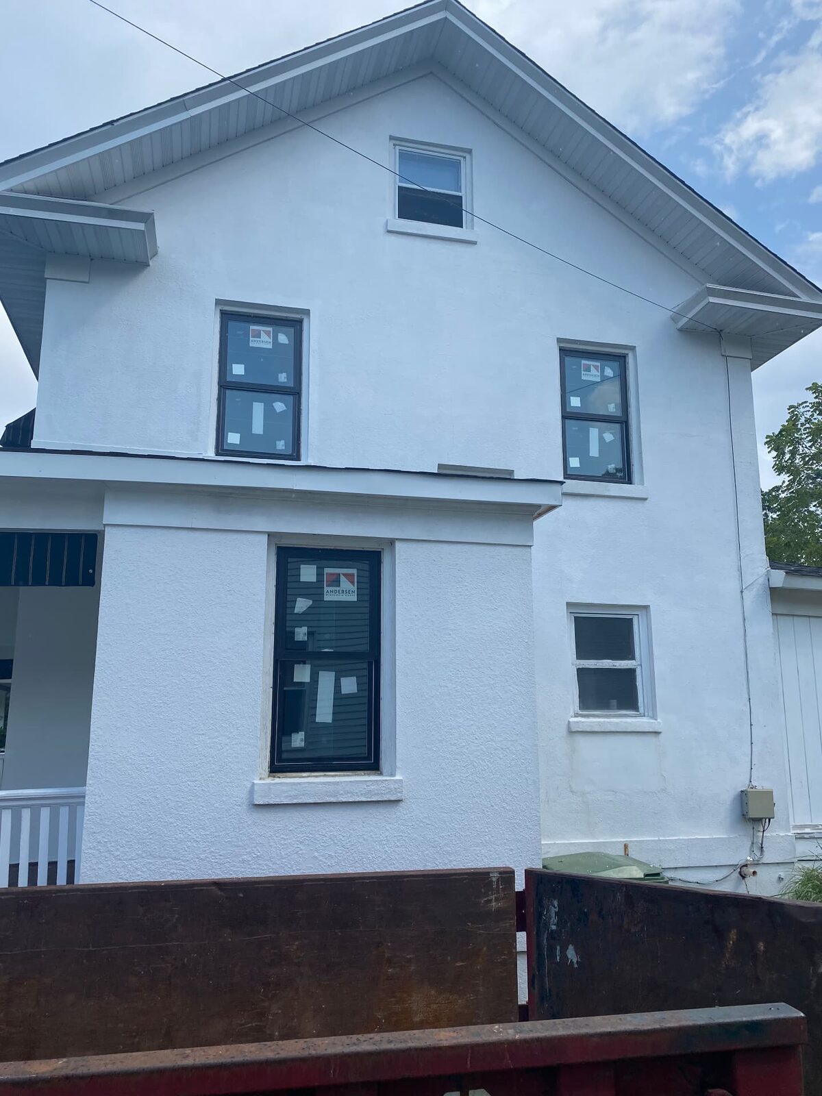 Completed two-story home exterior finished in white with dark window frames